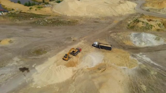 在采石场将碎石砂装载到卡车中的挖掘机的俯视图