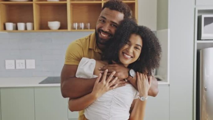 一对幸福相爱的黑人夫妇的肖像，他们互相抱着，在家里的室内享受一天。充满爱心的夫妻在一起度过了美好的时
