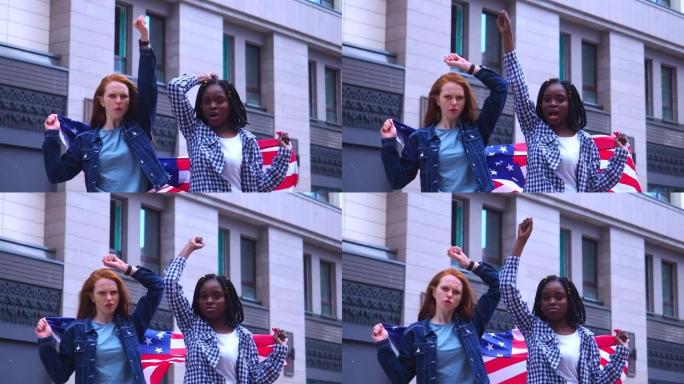 红头发的姜黄色妇女和非洲裔美国妇女在市中心举着美国国旗。