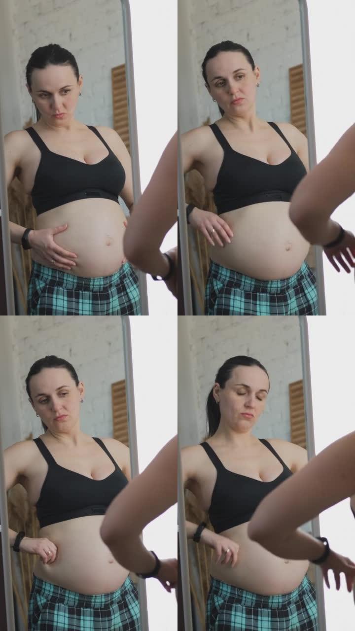 孕妇在镜子里看着腹部脂肪
