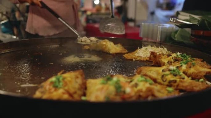 厨师使用巨型平底锅炸蛤蜊，泰国美味的街头美食。