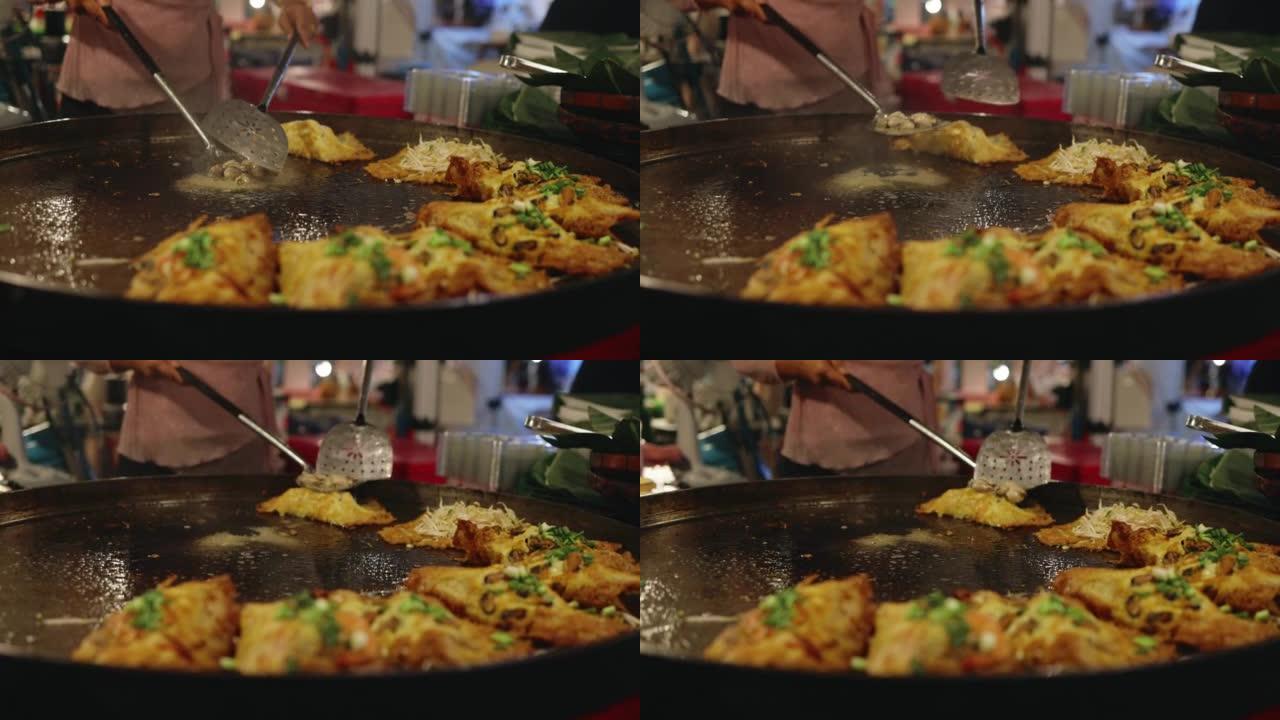 厨师使用巨型平底锅炸蛤蜊，泰国美味的街头美食。