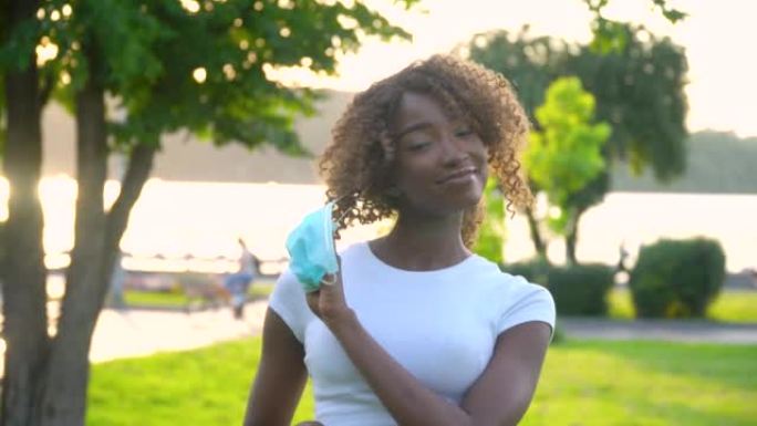 非裔美国女孩在公园摘下医用口罩。检疫结束