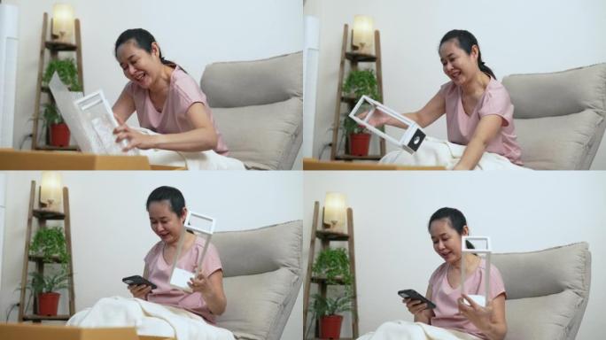 资深亚洲女性打开她在网上订购的一盏灯。