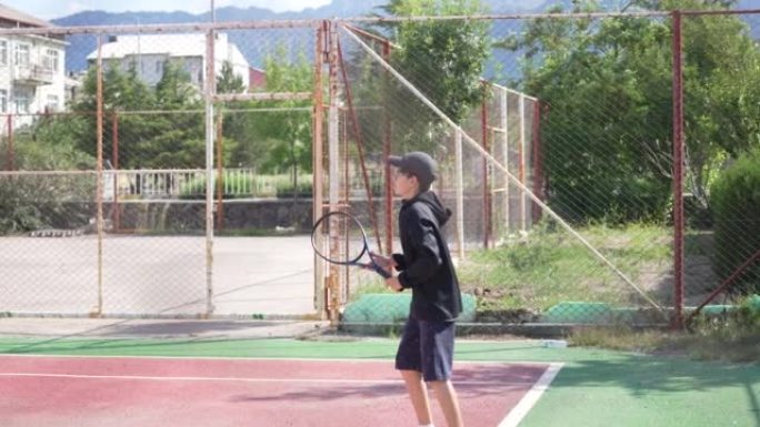 一个打网球的年轻少年。