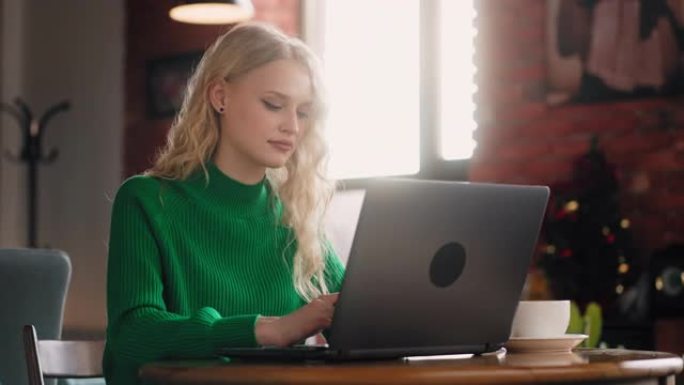 授权的远程工作: 在现代阁楼风格的咖啡店里，一位带笔记本电脑的女性自由职业者的肖像，在任何地方都能高