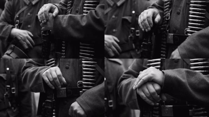 在第二次世界大战中，重演者穿着德国国防军机枪手步兵士兵的手的特写。德国士兵制服。士兵与机枪Mg 34