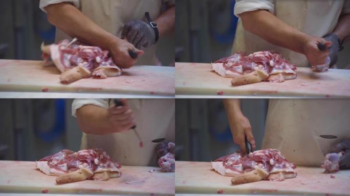 在香肠生产车间，一名男子用刀把肉和骨头分开