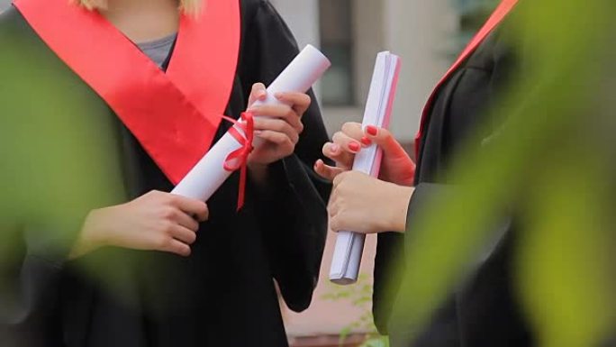 女学生拿着文凭在公园聊天，高等教育