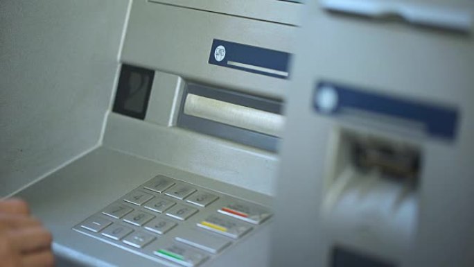 女银行客户在ATM上检查帐户余额并取回卡