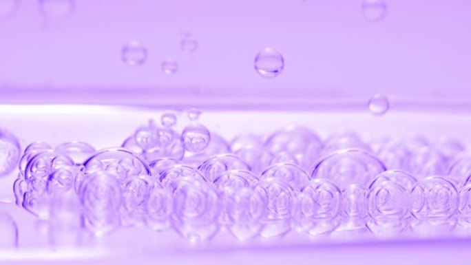 紫色透明气泡与另一个气泡一起沉入流体表面
