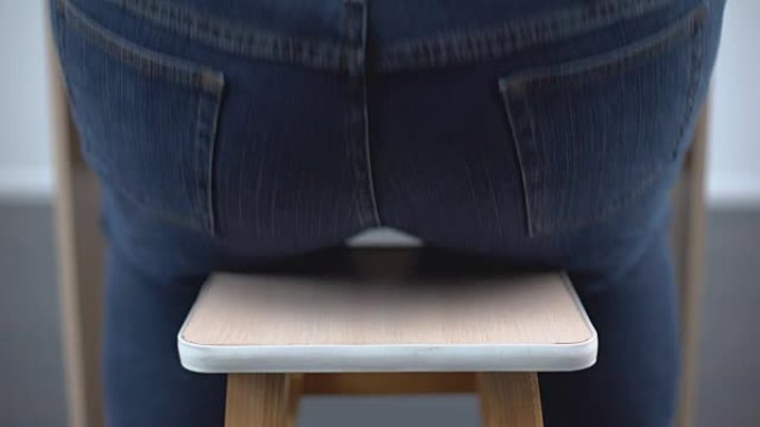 肥胖男子坐在椅子后视图，不健康的营养，荷尔蒙紊乱