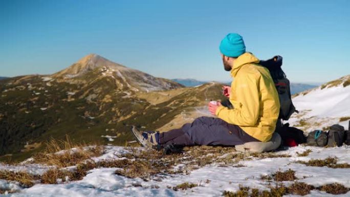 男性徒步旅行者在山顶享受小吃