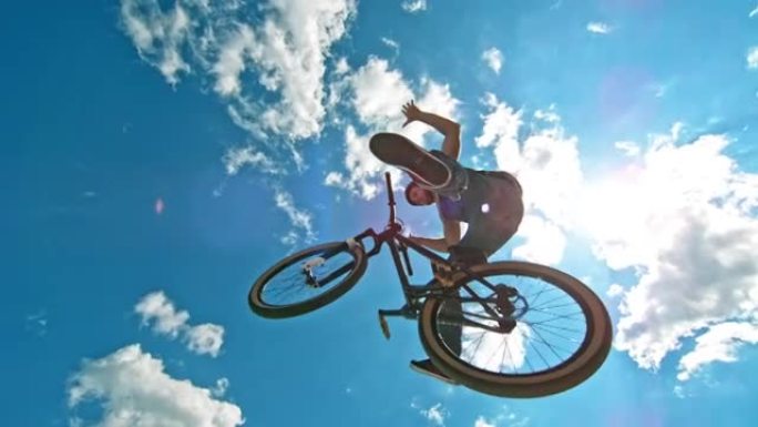 SLO MO男骑自行车的人在DJ自行车上空降时做了一个无手无脚的把戏