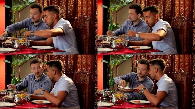 两名男子将食物放入餐厅的盘子中