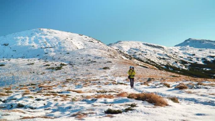 男性徒步旅行者在冬天的雪山中攀登