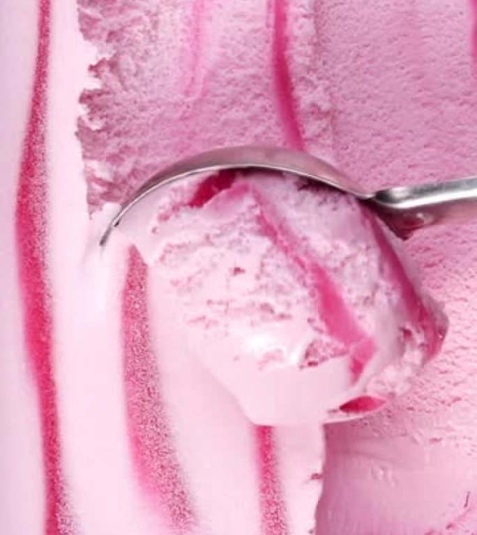 草莓味冰淇淋用钢勺慢慢舀，美味冰淇淋概念。