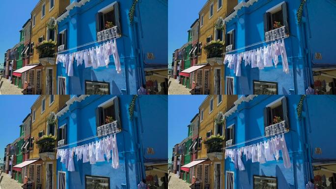 意大利生活布拉诺岛街蓝屋门面上的白色衣物烘干