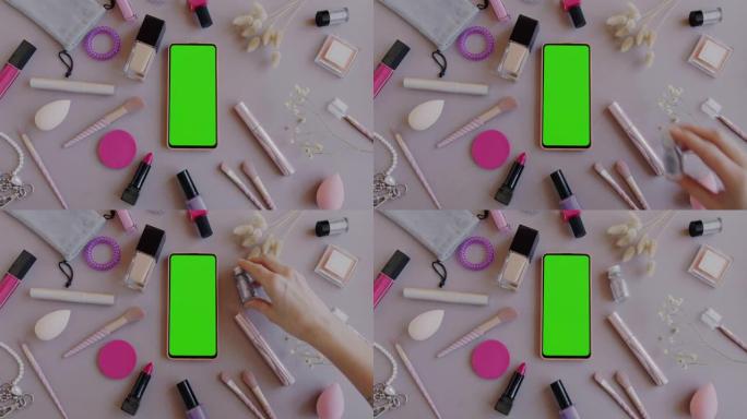 平铺女性配件和化妆工具，带绿色屏幕色度键智能手机，背景为灰色