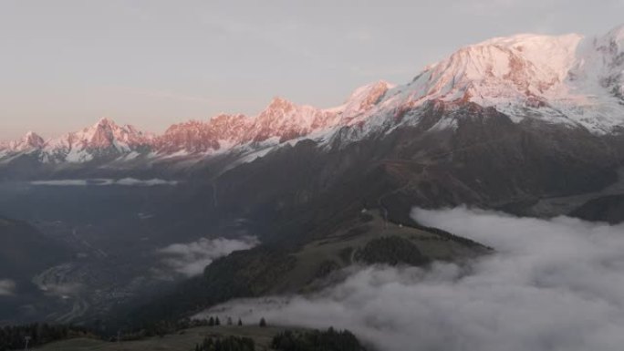 空中无人机拍摄了日落时分云反转的雪山线