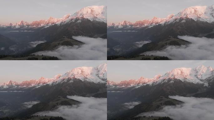 空中无人机拍摄了日落时分云反转的雪山线