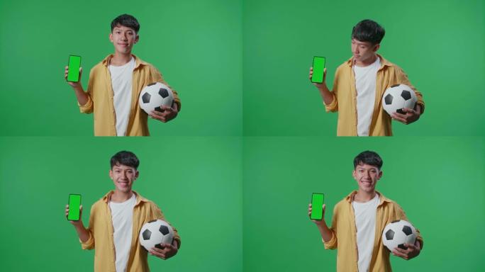 亚洲男孩的球显示模拟绿屏智能手机，并在绿屏背景上欢呼足球时摇摇头