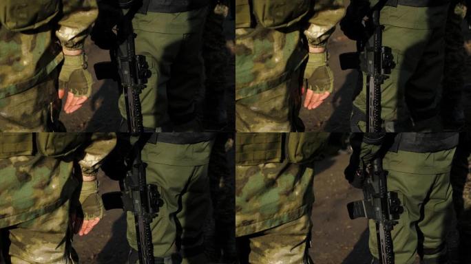 身着迷彩军装的士兵手持武器的特写镜头。