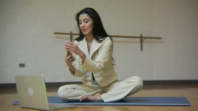 女人放下手机和笔记本电脑进行冥想