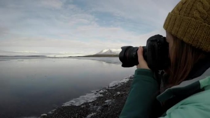 女人用单反相机拍摄冰川湖