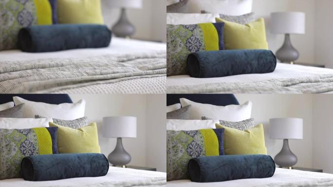现代卧室的奢华造型，配有彩色靠垫和枕头，装饰着柔软舒适的床，非常适合在寒冷的冬天早晨依偎在一起