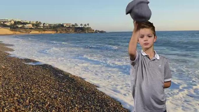 小男孩在海上背景脱帽欢迎