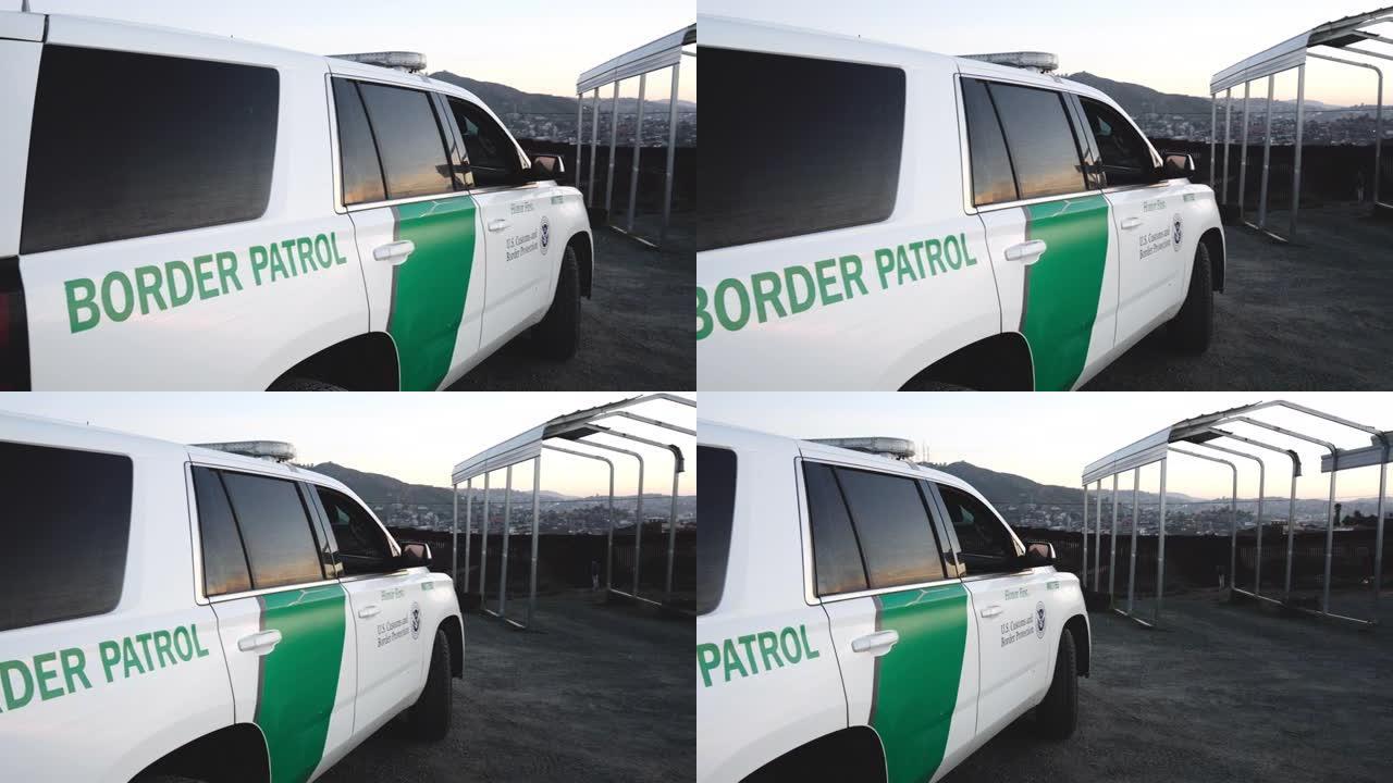 黄昏时分，美丽的云景，美国边境巡逻警车停在美国和墨西哥之间的国际边境隔离墙附近