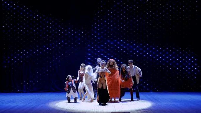 穿着风景优美的服装的人们在剧院的舞台上跳舞