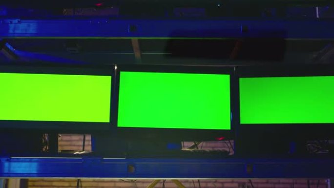 黑暗的现代房间里有很多绿色屏幕的显示器。监测、交易、分析室和保安系统的概念。视频切换器，电视控制处多