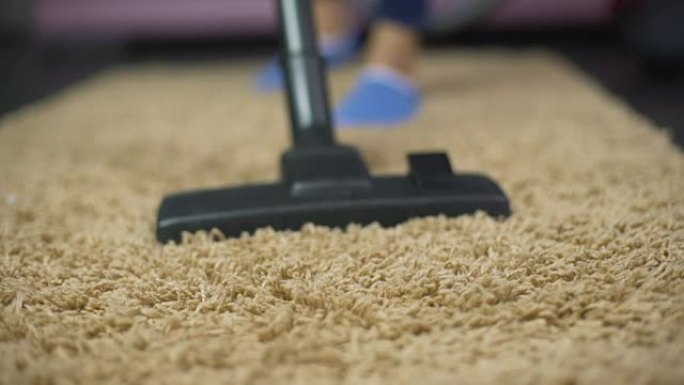 吸尘器扫除昂贵地毯上的灰尘的特写镜头，家庭卫生