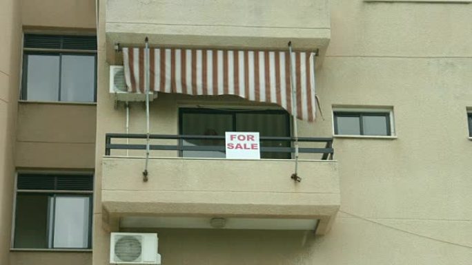 公寓阳台上的待售标志。房地产代理服务。
