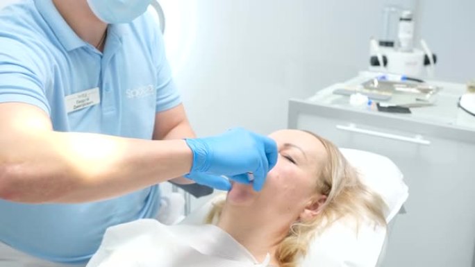 液体围堰从漂白剂optragat旋转撒布机的作用下分离牙龈给病人卫生巾她擦拭口腔牙科手术牙科治疗修复