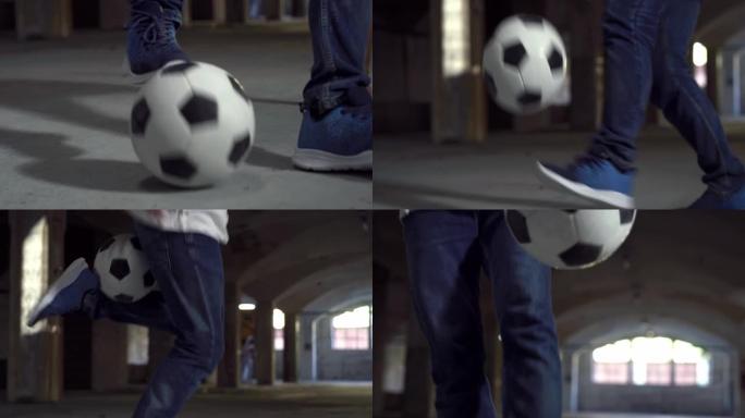 手持动作射击: 专注于有才华的年轻足球运动员巧妙地玩弄球的腿。男子在地下停车场展示他的自由式足球技巧