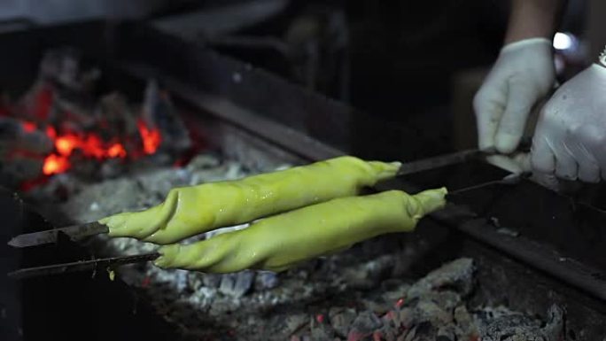 街头小贩在木炭烤架上烹饪传统菜肴，食物
