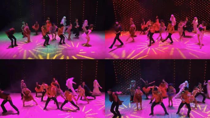 穿着鲜艳服装的人们在现代舞台上疯狂地在五颜六色的灯光中跳舞