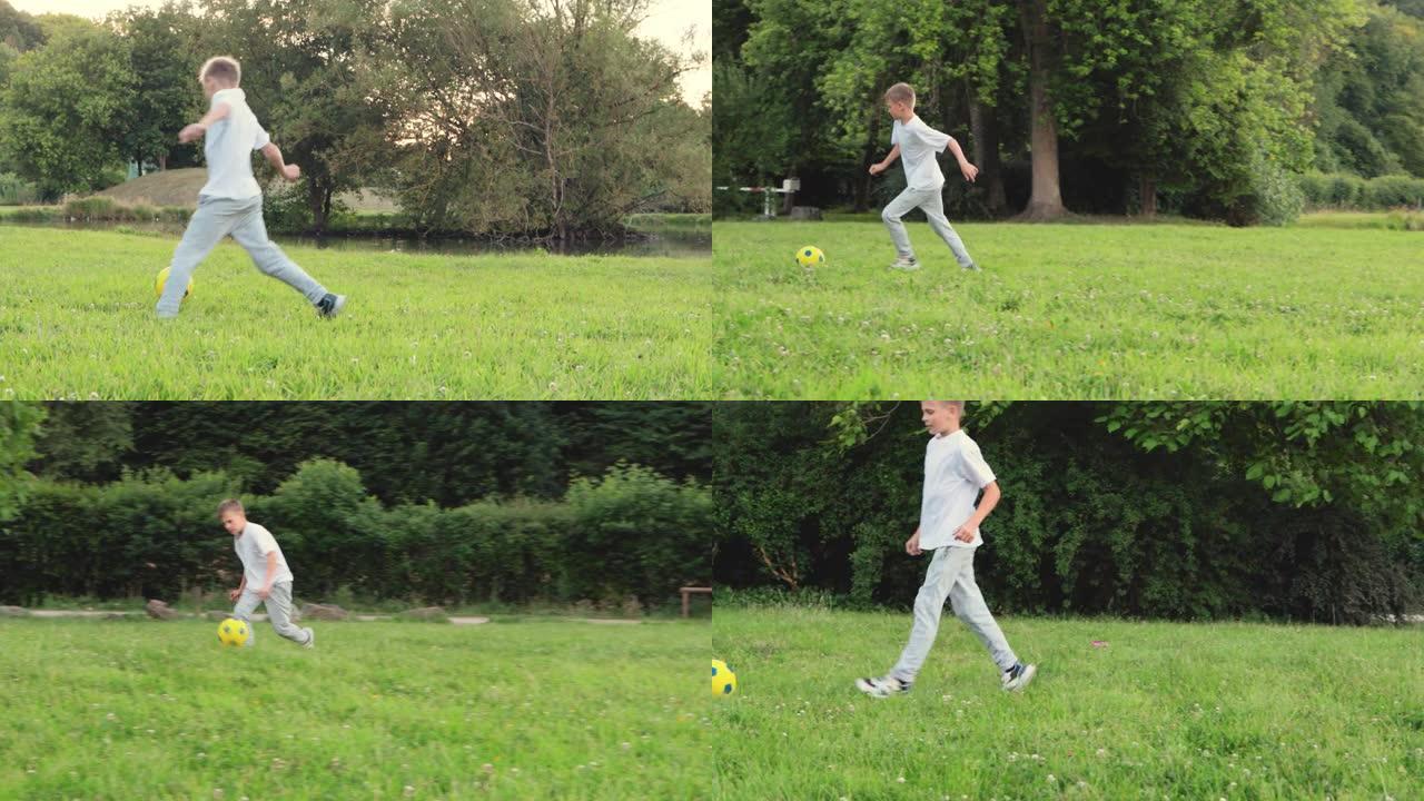 一个穿着运动服的金发的欧洲男孩在公园里在绿色的草地上打球，男孩在公园里追球