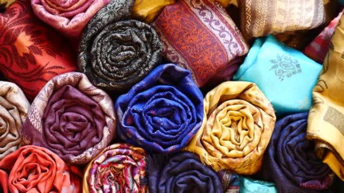 五颜六色的织物、床罩和带有不同东方图案的方巾。