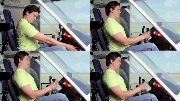 一个兴奋的年轻人坐在飞行模拟器里，在驾驶舱甲板上转动控制装置