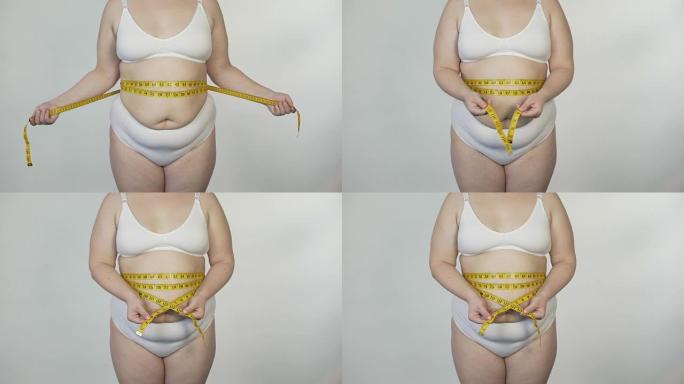 肥胖妇女穿着白色内衣测量腰部，动机和节食