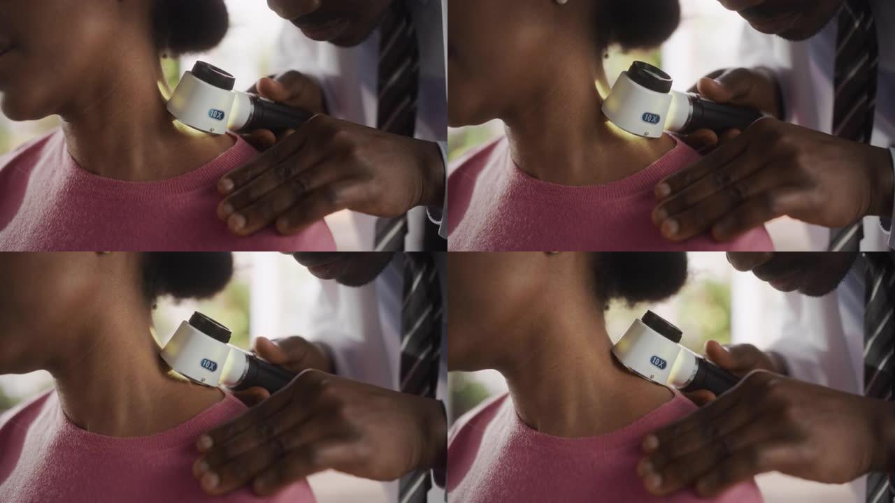 在对诊所进行健康检查期间，一名黑人皮肤科医生使用医用放大镜检查非洲女性患者皮肤上的任何损伤。在医院工