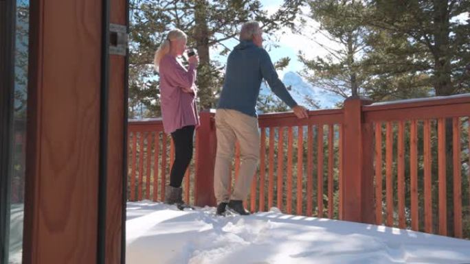 成熟的夫妇喜欢在小屋阳台上喝热饮和交谈