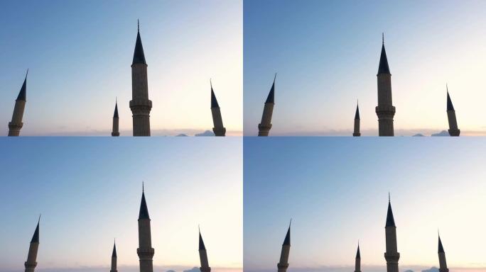 红色日落天空背景上的四个清真寺尖塔。