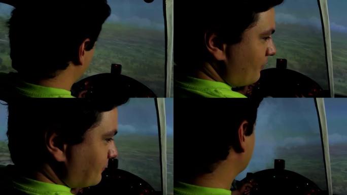 一个年轻人假装是飞行员，在飞行模拟器里玩电子游戏
