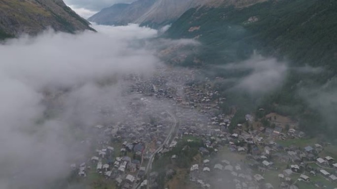 空中无人机拍摄了被低云覆盖的采尔马特小山村