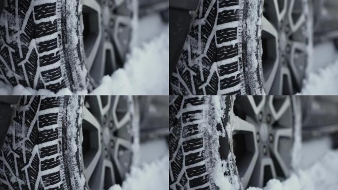 汽车大车轮站立，并在冬天从雪乡道路上未经处理而缓慢旋转，积雪深